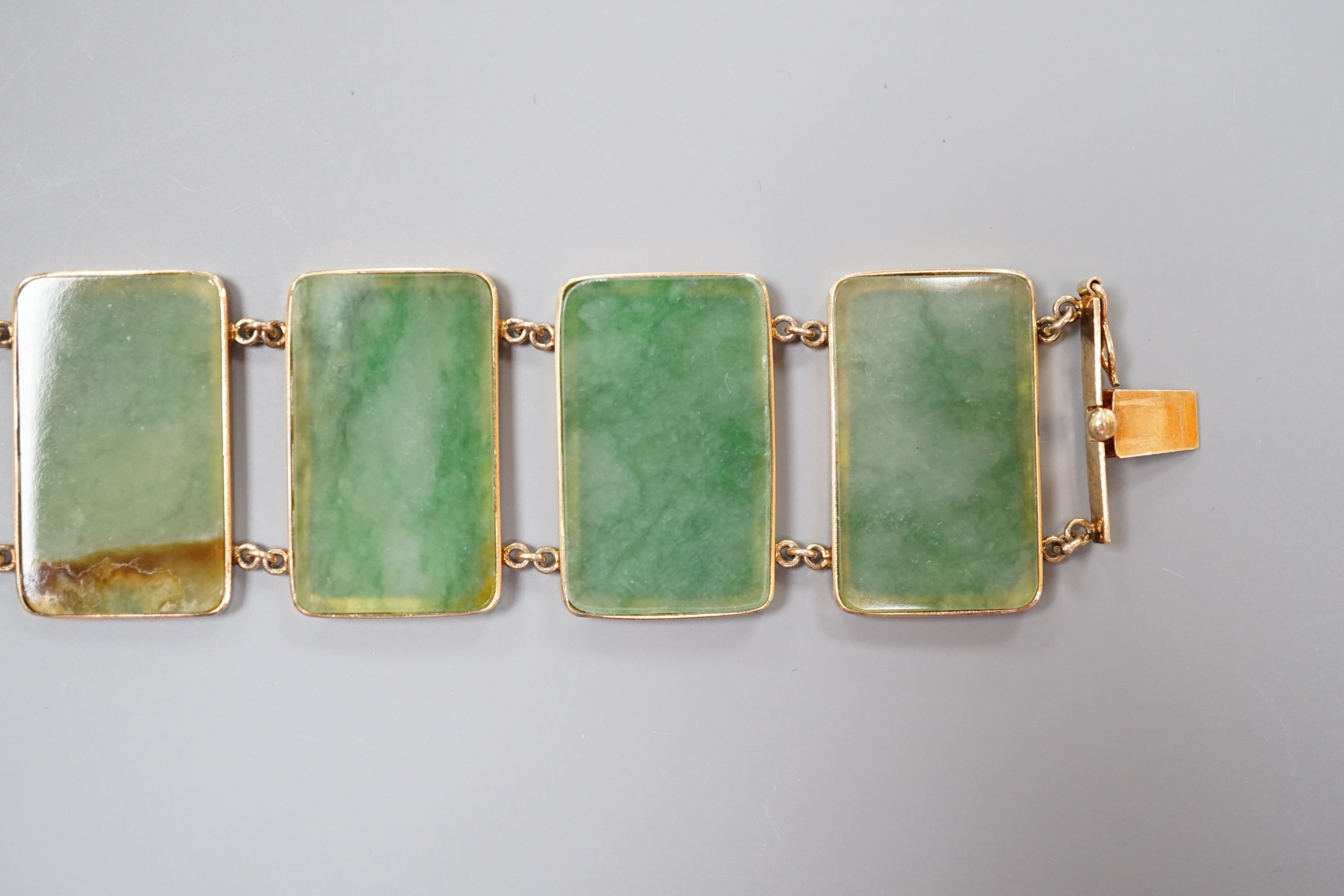 A 585 yellow metal and jade bracelet, set with eight rectangular panels, 18cm, gross weight 26.5 grams.